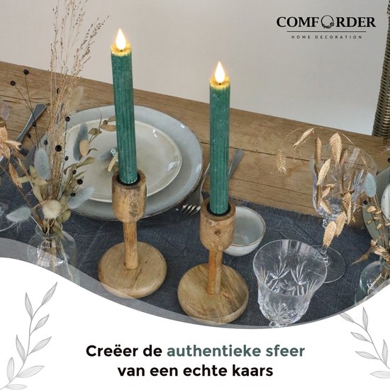 Twee mosgroene, geribbelde LED-kaarsen op houten kandelaars op gedekte tafel.