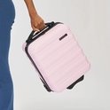 Een hand wordt gebruikt om de lichtroze Cabin Max handbagage koffer vast te houden.