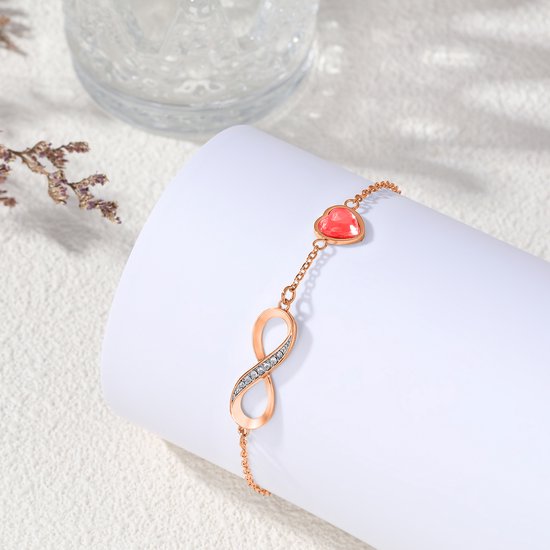 Rosegouden armband met oneindigheidssymbool bezet met zirkonia en een rood hartje.