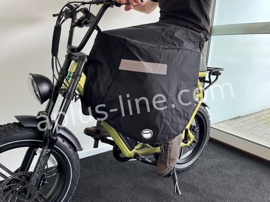 Zwart beenkleed met reflectiestreep, bedekt de voorkant van een groene fatbike.