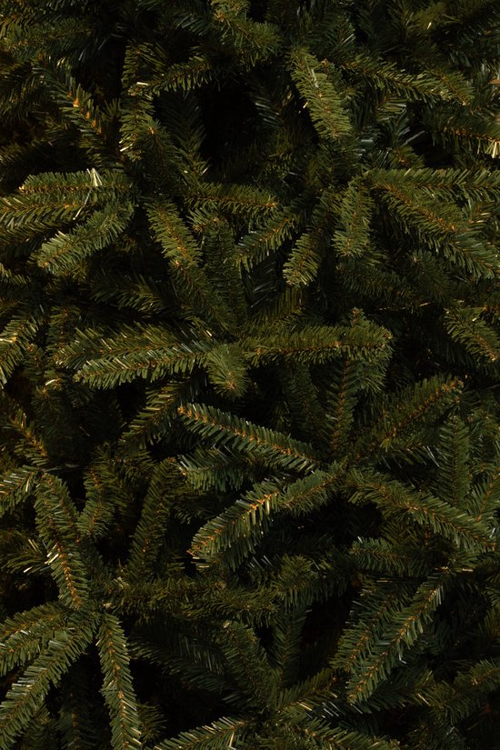 Gedetailleerd beeld van dichte, donkergroene kunstkerstboomtakken met lichte accenten.