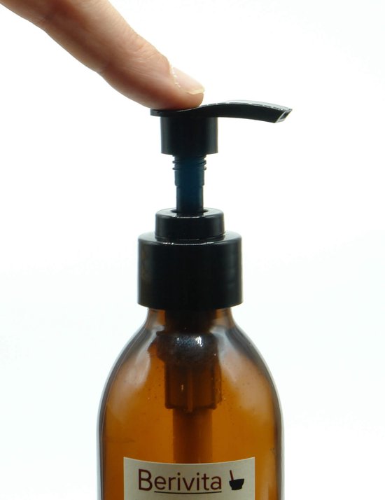 Vinger drukt op de zwarte pomp van een bruine glazen fles.