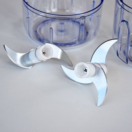 Twee metalen hakmessen met witte plastic houders voor de hakmolen.