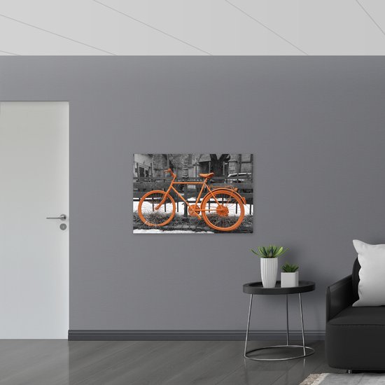 WallClassics - Muursticker - Oranje Fiets tegen Zwart Witte Achtergrond - 105x70 cm Foto op Muursticker