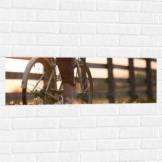 WallClassics - Muursticker - Fietser door Bloemenveld - 90x30 cm Foto op Muursticker