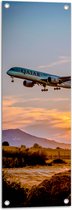 WallClassics - Tuinposter – Blauw Laagvliegend Vliegtuig met Zon - 30x90 cm Foto op Tuinposter  (wanddecoratie voor buiten en binnen)