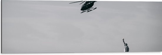WallClassics - Dibond - Helikopter zwevend boven Vrijheidsbeeld in New York - 90x30 cm Foto op Aluminium (Wanddecoratie van metaal)