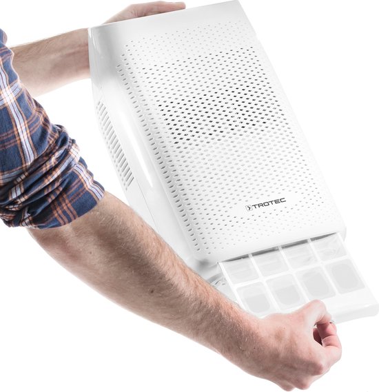 Witte Trotec luchtontvochtiger met uittrekbaar filterbakje, vastgehouden door handen.