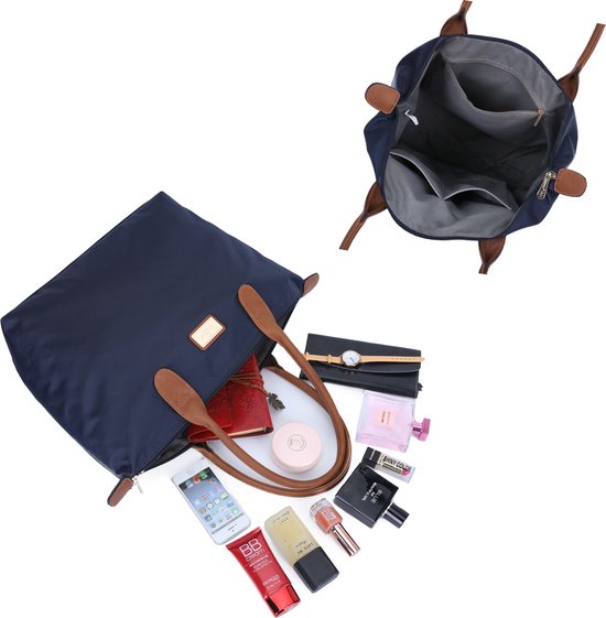 Sac bleu marine en tissu avec anses marron et divers articles de cosmétique.