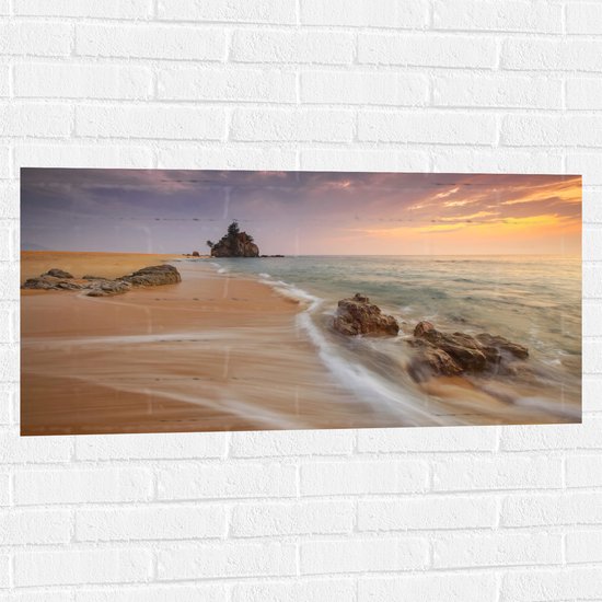 WallClassics - Muursticker - Zee met Rotsen bij Pastelkleurige Lucht - 100x50 cm Foto op Muursticker