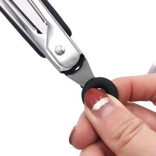 Main tenant une pince de cuisine en acier inoxydable avec une poignée en silicone noire, avec un anneau de suspension.