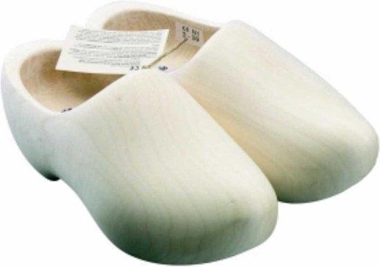 Een paar naturel houten klompen met labels, op een witte achtergrond.