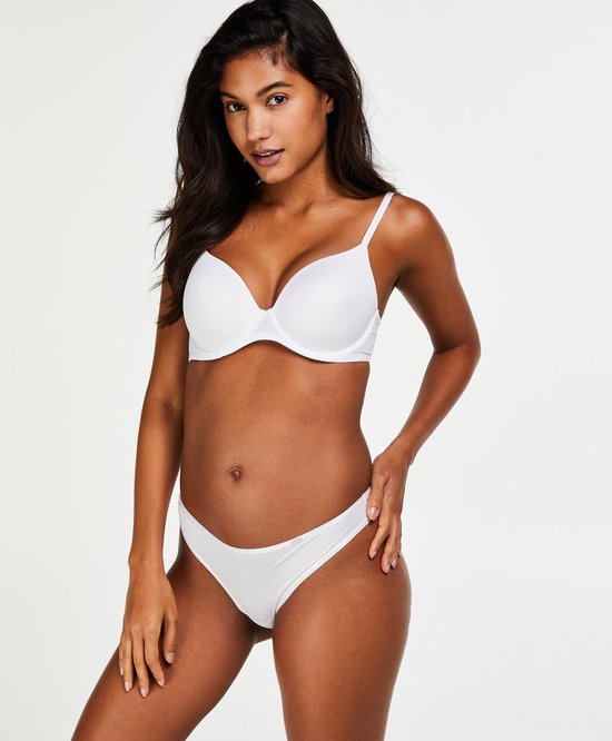 Model in witte beha en slip, van voren bekeken, met de hand op de heup.