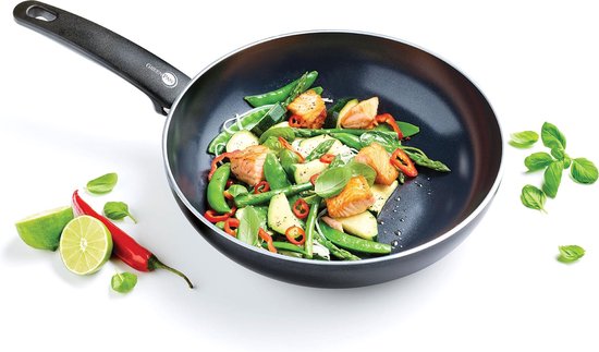 Zwarte wokpan gevuld met zalm, peultjes, taugé, rode peper en basilicum.