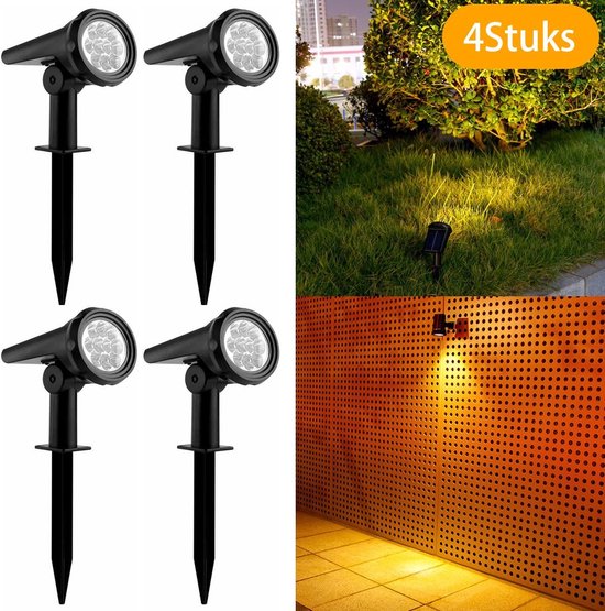 Vier zwarte spots met 9 leds verlichten gazon en muur met geperforeerde panelen.