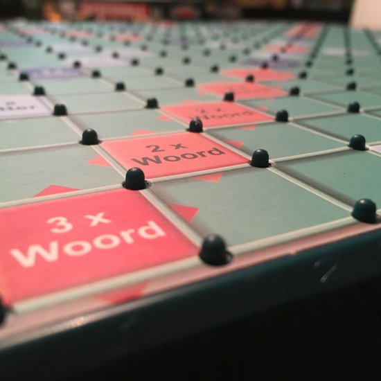 Close-up van een Scrabble XL bord met rode '2x Woord' en '3x Woord' vakjes.