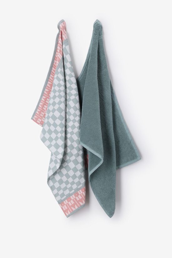 Twee hangende keukendoeken, één effen groenblauw, de ander met groenblauw schaakbord en oranje hartjes.