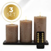Set van drie taupe kleurige LED-stompkaarsen op een zwarte houder, met een afstandsbediening.