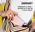 Een roze powerbank wordt in een gestreepte tas gestoken.