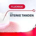 Close-up van een tand die beschermd wordt door fluoride. Tekst: Fluoride voor sterke tanden.