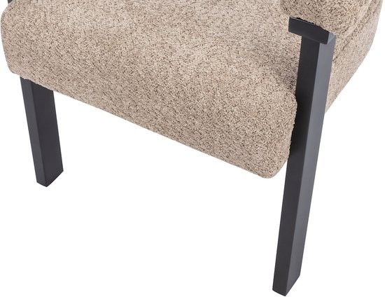 Detail van de beige bouclé stof en de hoekige zwarte poot van een stoel.