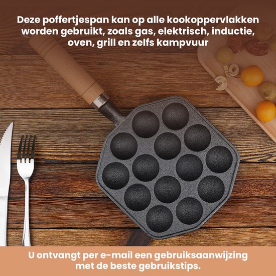 Gietijzeren poffertjespan met 14 holtes en houten handvat, op een houten tafel met bestek en kleine gebakjes.