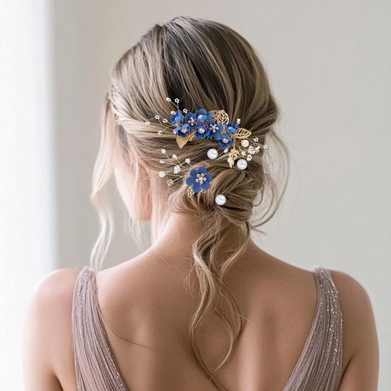 Een bruid met opgestoken haar, versierd met blauwe bloemen haaraccessoires, parels en strass.