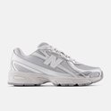 Een lichtgrijze New Balance 740 sneaker met metallic zilveren accenten, van de zijkant gezien.