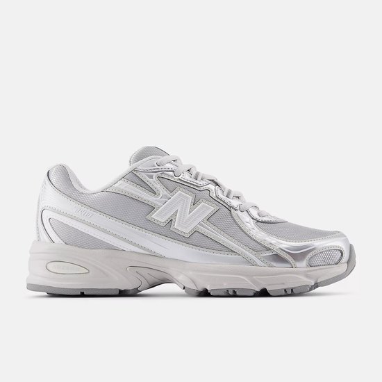 Een lichtgrijze New Balance 740 sneaker met metallic zilveren accenten, van de zijkant gezien.