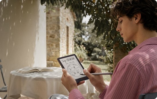 Man met roze gestreepte blouse gebruikt stylus op zwarte BOOX Go e-reader met tekst.