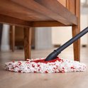 Witte en rode mopkop onder een houten meubel op een houten vloer.