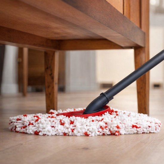 Witte en rode mopkop onder een houten meubel op een houten vloer.