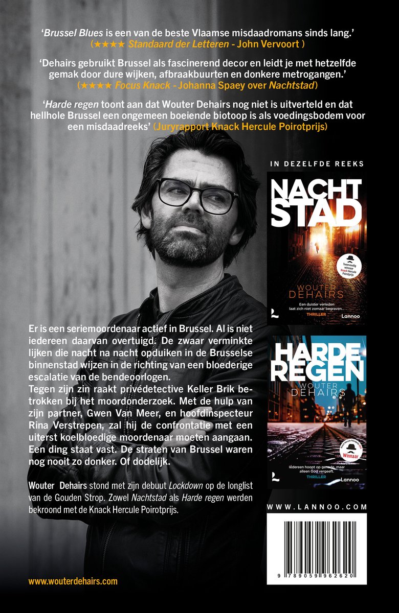 Wouter Dehairs staat op de foto met een donker overhemd en een grijze jas, kijkend naar de camera. Op de achtergrond de boeken 'Nachtstad' en 'Harde regen'.