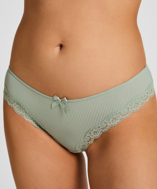 Close-up van een vrouw in mintgroene rib-slip met strikje en kanten randje.