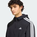 Close-up van zwart Adidas windjack met witte strepen en het Adidas-logo op de borst.