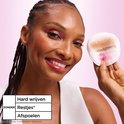 Vrouw met donkere huid en roze oogschaduw, houdt een wattenschijfje met make-up vast. Tekst: Hard wrijven, Restjes, Afspoelen.