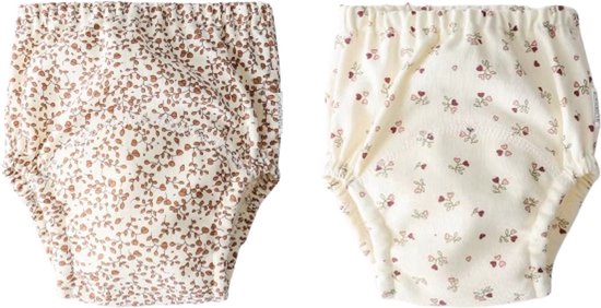 Twee oefenbroekjes: één met bruine bloemenprint, één met roze bloemetjes en strikjes op crèmekleurige achtergrond.