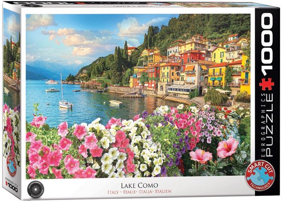 Doos van 1000 stukjes puzzel, met een foto van het Comomeer in Italië, met kleurrijke huizen en bloemen.