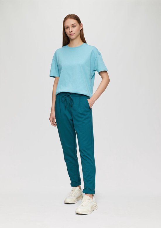Model van achteren gezien in turquoise joggingbroek met omslag aan de onderkant.