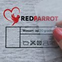 Hand toont een waslabel met 'RedParrot' logo en de tekst 'Wassen op 30 graden'.