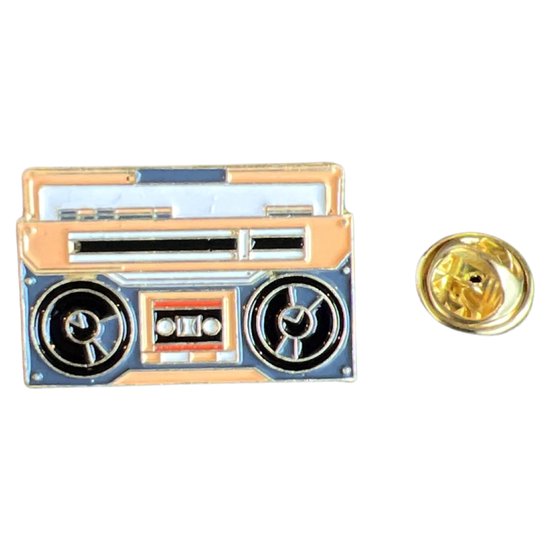 Broche radio cassette dorée et orange avec des détails noirs et gris.