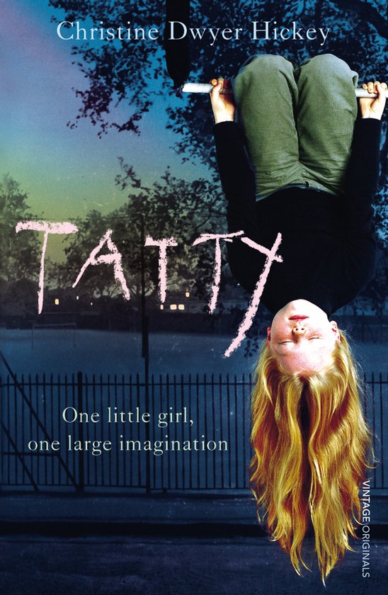 Een meisje met blond haar hangt ondersteboven aan een paal. De titel 'TATTY' staat op het boek.
