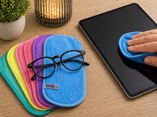 Een stapel van vijf microvezeldoekjes in blauw, mintgroen, geel, paars en roze, met daarop een zwarte bril. Rechts een hand die een tablet schoonmaakt met een blauw doekje.