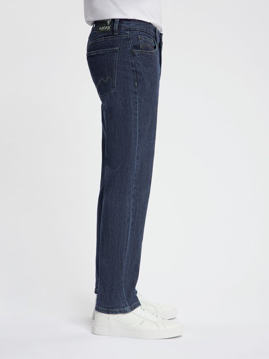Zijkant van een donkerblauwe jeans met gele stiksels.