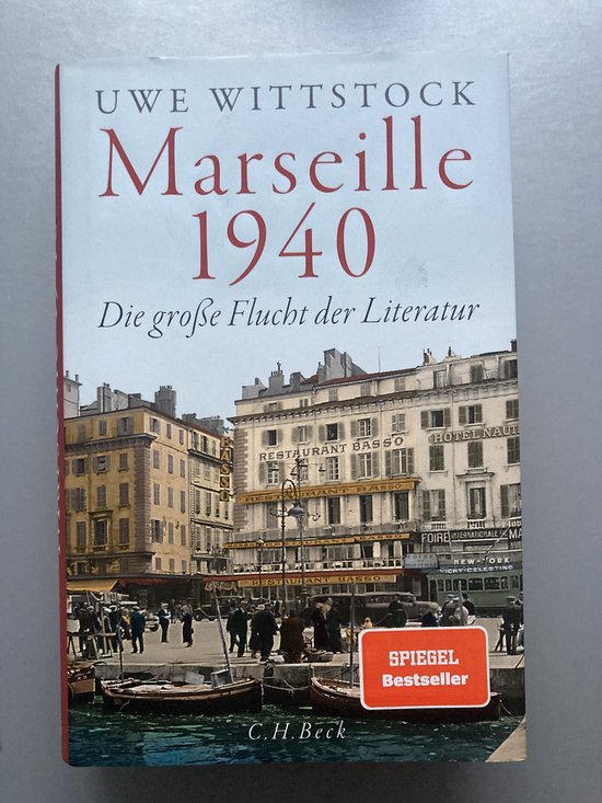 Boekcover van "Marseille 1940" door Uwe Wittstock. Toont een historische straatscène met gebouwen en mensen. Met "SPIEGEL Bestseller" sticker.