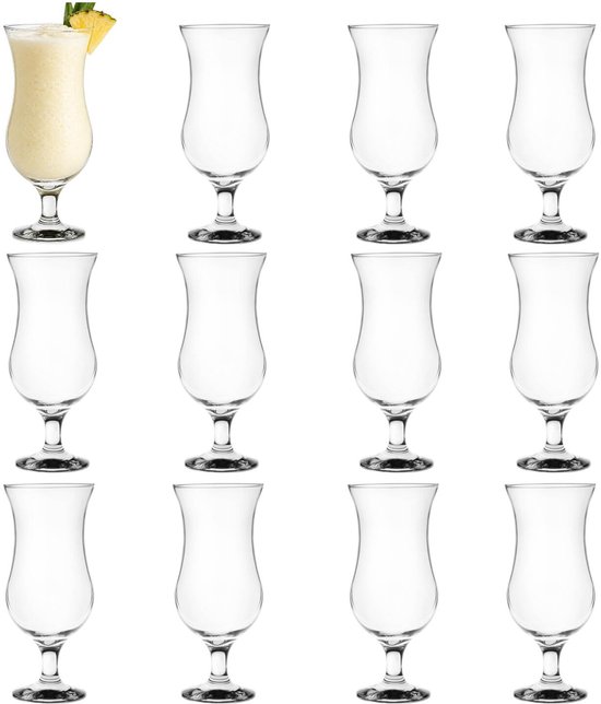 Douze verres à cocktail vides avec un verre rempli d'une tranche d'ananas à l'avant.