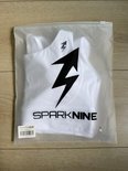 Witte sportbeha in een transparante plastic verpakking met SparkNine logo.