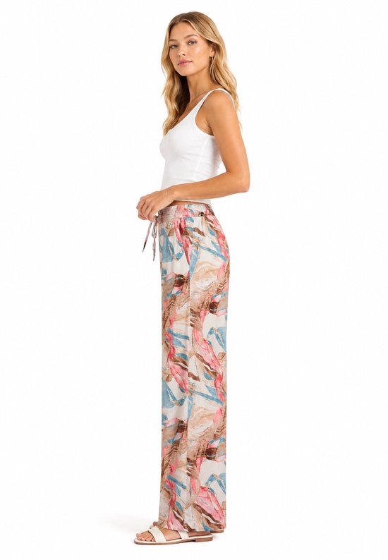 Model van opzij gezien met wijde broek met aquarelprint in blauw, roze en bruin.