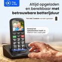 Een seniorentelefoon staat op het oplaadstation, met een foto van een ouder echtpaar op het scherm.
