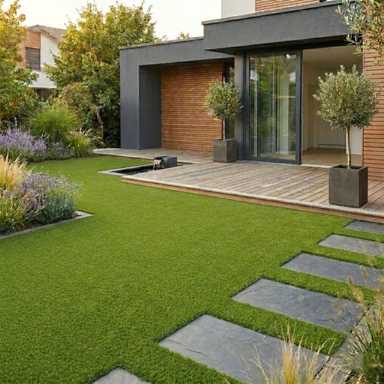 Moderne tuin met houten terras, kleine waterpartij en kunstgras met grijze tegels.